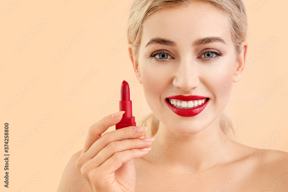 Beautiful young woman with lipstick on color background