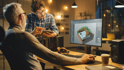 Wall Mural - in the evening creative middle aged video game developer works on a desktop computer with screen 3d 