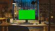 © Gorodenkoff - Desktop Computer with Mock-up Green Screen Standing on the Wooden Desk in the Modern Creative Office. In the Background Warm Evening Lighting and Open Space Studio with City Window View.