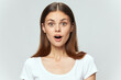 © SHOTPRIME STUDIO - A surprised woman with an open mouth in a white t-shirt looks ahead
