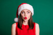 Closeup photo of attractive cute charming lady red pomade plump lips look side empty space interested shocking sale offer wear santa cap xmas costume isolated green pastel color background