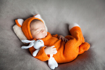 Sleeping newborn baby in cute fox outfit