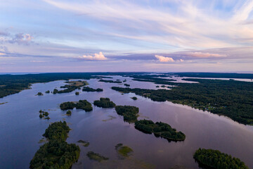 panoramic view of the lake with many islands on one of them there is an ancient temple made of wood at sunset filmed from a drone