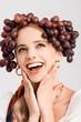 © LIGHTFIELD STUDIOS - rustic blonde woman with grapes on head laughing isolated on white