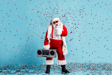 Full Length Photo Of Retired Grandfather Grey Beard Sing Modern X-mas Carol Mic Confetti Hold Retro Radio Wear Santa Costume Suspender Sunglass Cap Boots Isolated Blue Color Background