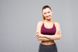 © dianagrytsku - Happy fitness woman standing with arms folded over gray background