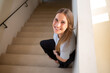 © BullRun - Top view of caucasian happy hipster girl in casual wear standing on stairs enjoying free time smiling looking at camera, from above picture of young 20s with natural beauty skin woman laughing indoors