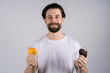 © Ivan - Man with long beard shows avocado and orange. Fruit and healthy organic food. Dieting and fitness.