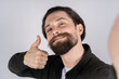 © Ivan - Young man hold the camera with hand and shows thumb up. Make selfie