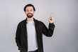 © Ivan - Young smiling man points with fingers up isolated on white background.