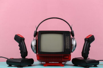 Sticker - Retrogaming. Video game competition. Old TV with headphones and two joysticks on pink background. Attributes 80s