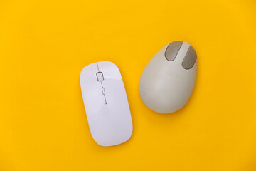 Wall Mural - Old and modern pc mouse on a yellow background. Top view