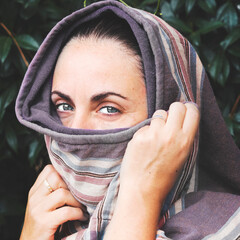 Portrait of a blue eyed woman wearing a keffiyeh headscarf. Religion and cultures.