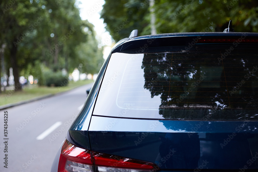 Back window of blue car parked on the street in summer sunny day, rear ...
