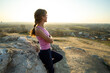 © bilanol - Woman hiker leaning on a big rock enjoying warm summer day. Young female climber resting during sports activity in nature. Active recreation in nature concept.