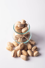 Pistachios in glass bottles on white background. Copy space.