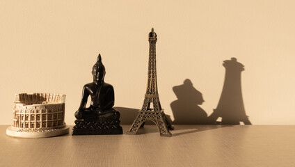  Coliseum, Buddha and Effeil tower on a wooden table with their shadow