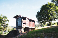 Old Wooden Narrow House On Top Of A Hill Against Blue Sky