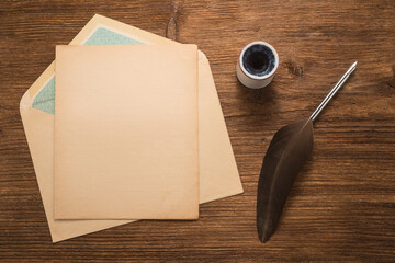 Wall Mural - Envelope, goose feather, inkwell on a wood table  	