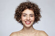 Portrait of smiling beautiful young girl with curly hair and nude makeup