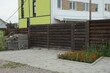 © butus - one closed brown rural wooden gate and fence made of planks on the street