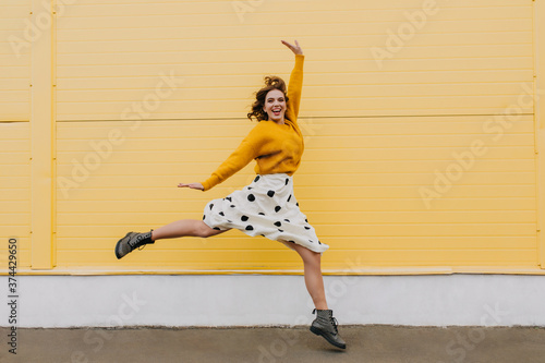 Fotografía Full-length portrait of excited trendy woman running on yellow background