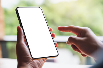 Mockup image of a woman holding and pointing finger at mobile phone with blank white desktop screen