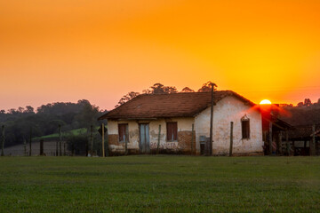 Wall Mural - paisagem de casa velha na fazenda com pôr-do-sol e gramado verde