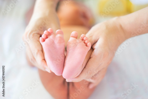 Fotografía close up mother holding new born baby toddler feet in her palm, warm love and ca
