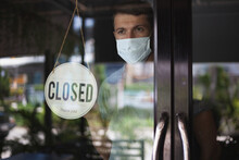 Chef In Safety Mask Hanging Up Sign Closed On Restaurant Door.