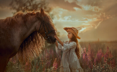 Little girl with red tinker horse (Gypsy cob) in summer evening field