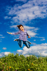 Wall Mural - Girl jumping, running against cloudy sky