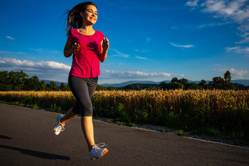 Teenage girl running against blue sky 