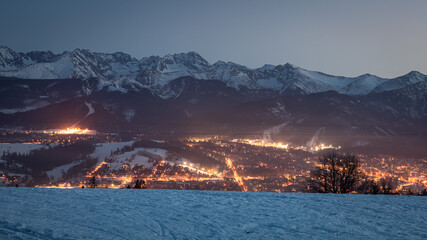 Wall Mural - Dusk over illuminated zakopane in winter, aerial view