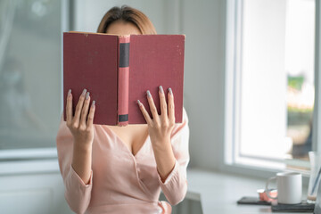 Closeup woman hand holding a book to read.