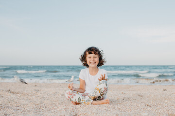 Portrait of smiling child girl sitting on a beach