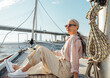 © Artem Varnitsin - Stylish mature woman sitting on a yacht bow. Senior female enjoying vacation on a private sailboat.
