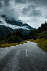 Wall Mural - Mist and fog clouds hanging in the mountain on a rainy weather day with mountain and tree shilhouettes. Dramatic mountain view. Austrian Alps, Salzkammergut in Austria, Europe