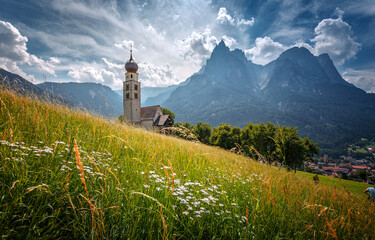 Wonderful summer nature landscape. image of alpine highlands with fresh green grass in sunny day. Wonderful countryside with mountain. San Valentino Church. Kastelruth village. Dolomite Alps. Italy