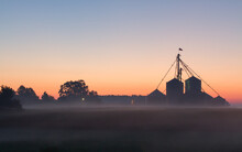 A Midwest Farm Silhouetted At Dawn