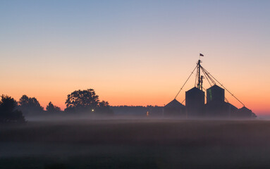 a midwest farm silhouetted at dawn