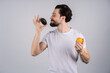 © Ivan - Man with long beard shows avocado and orange. Fruit and healthy organic food. Dieting and fitness.