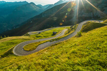 Motorcycle Rider Driving In Alps, Beautiful Nature With Clear Sky. Travel And Freedom, Outdoor Activities. Low Angle