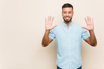 Young south-asian man showing number ten with hands.