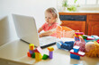 © Ekaterina Pokrovsky - Happy toddler girl with laptop and toys