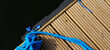 Yacht rope detail image on figure eight cleat hitch on wooden deck. Close up of boat rope tied with free space for text. Sailboat winch.
