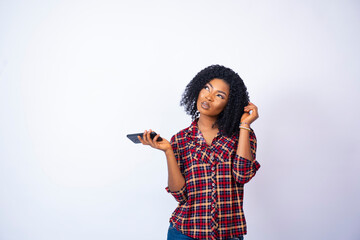 Wall Mural - young back woman holding her phone thinking about something, holding a bit of her hair