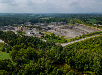 Aerial view of opencast mining quarry with lots of machinery at work in middle of forest on Pennsylvania, USA