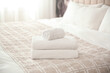 © New Africa - Clean white towels on bed at home