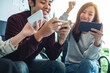 © Farknot Architect - A group of young people having fun and celebrating while watching and playing games on mobile phone together